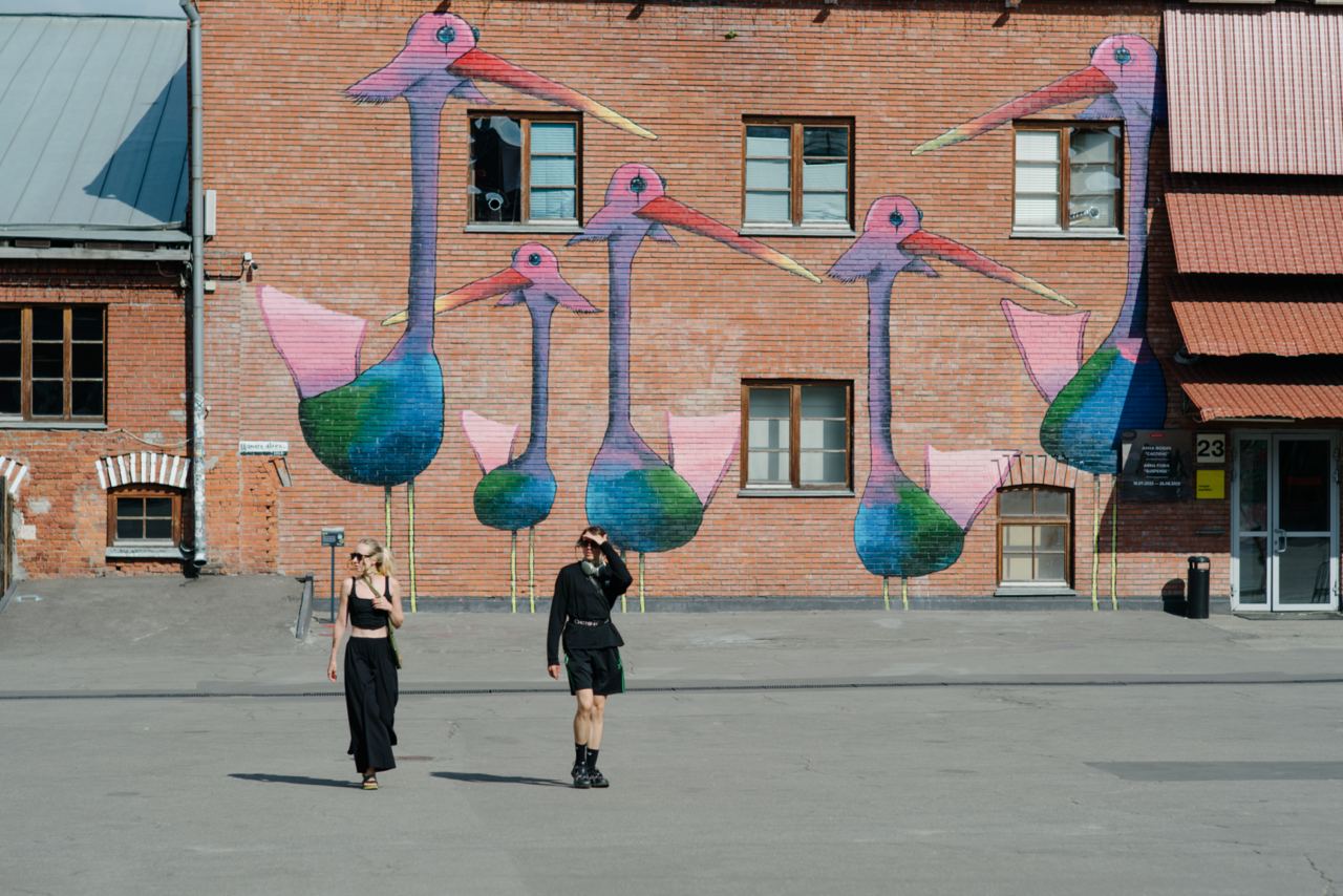 Teenagers walking past a colorful street mural symbolizing self-discovery, body acceptance, and self-esteem development during adolescence