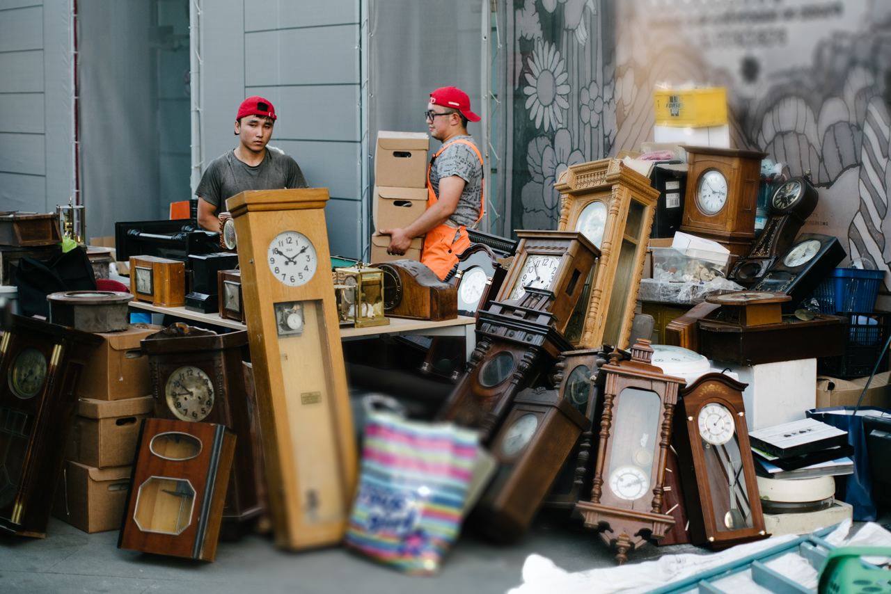 Men surrounded by numerous clocks - a visual metaphor for accumulated fatigue, time pressure, and the risk of burnout
