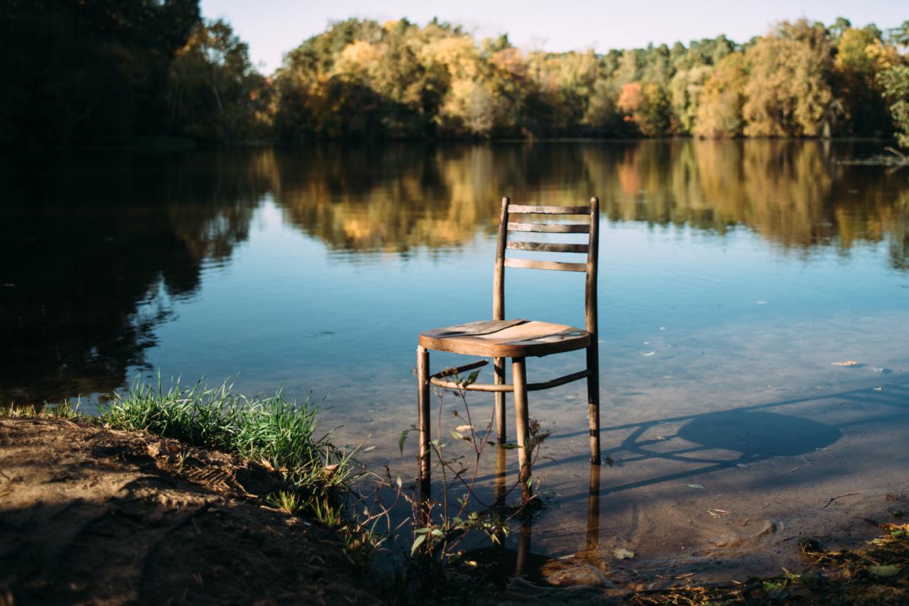 Chair by a lakeside with calm water - a symbol of proper hydration and maintaining a healthy drinking routine