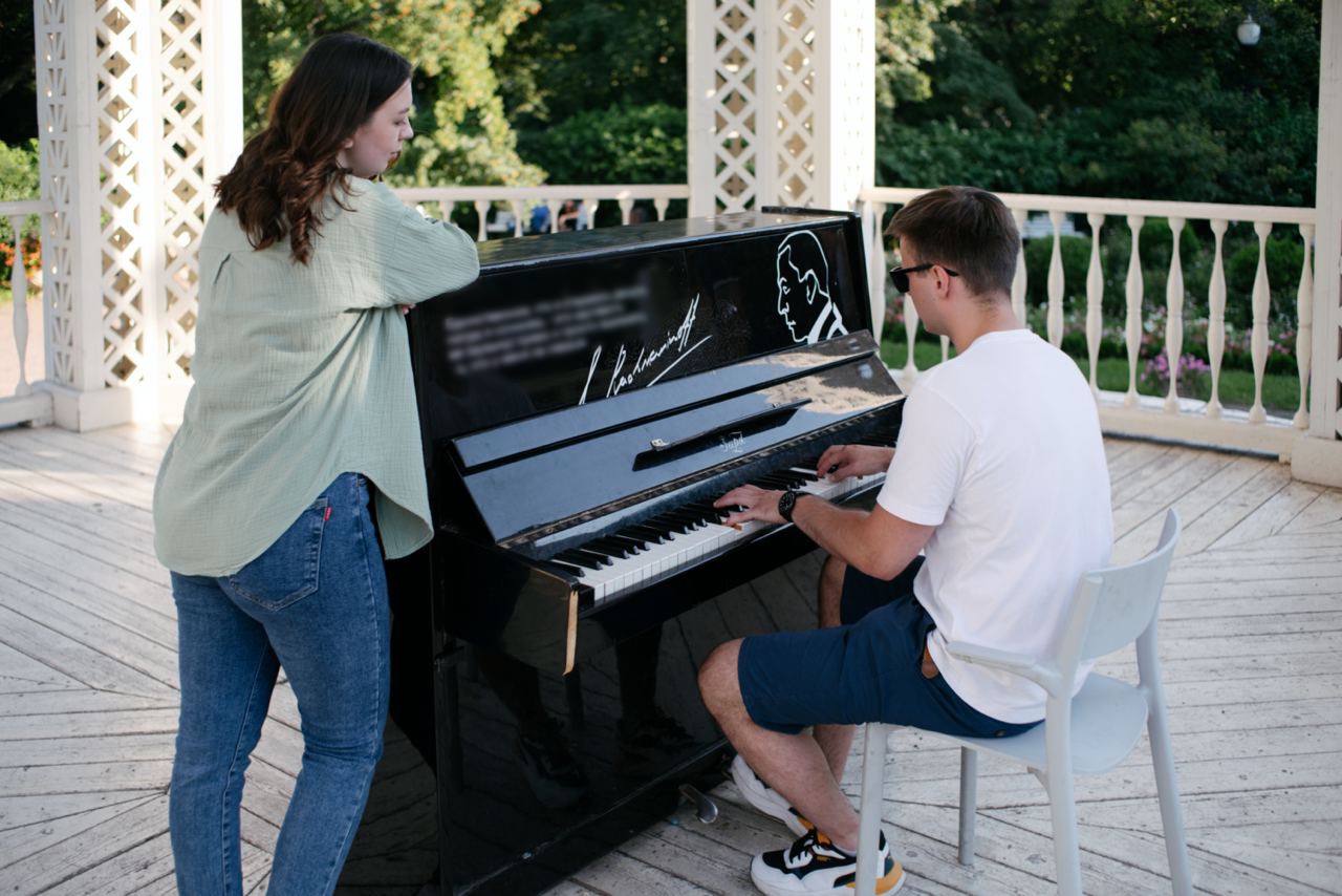 Man playing piano while a woman watches, illustrating meeting new people, communication, and romantic attraction