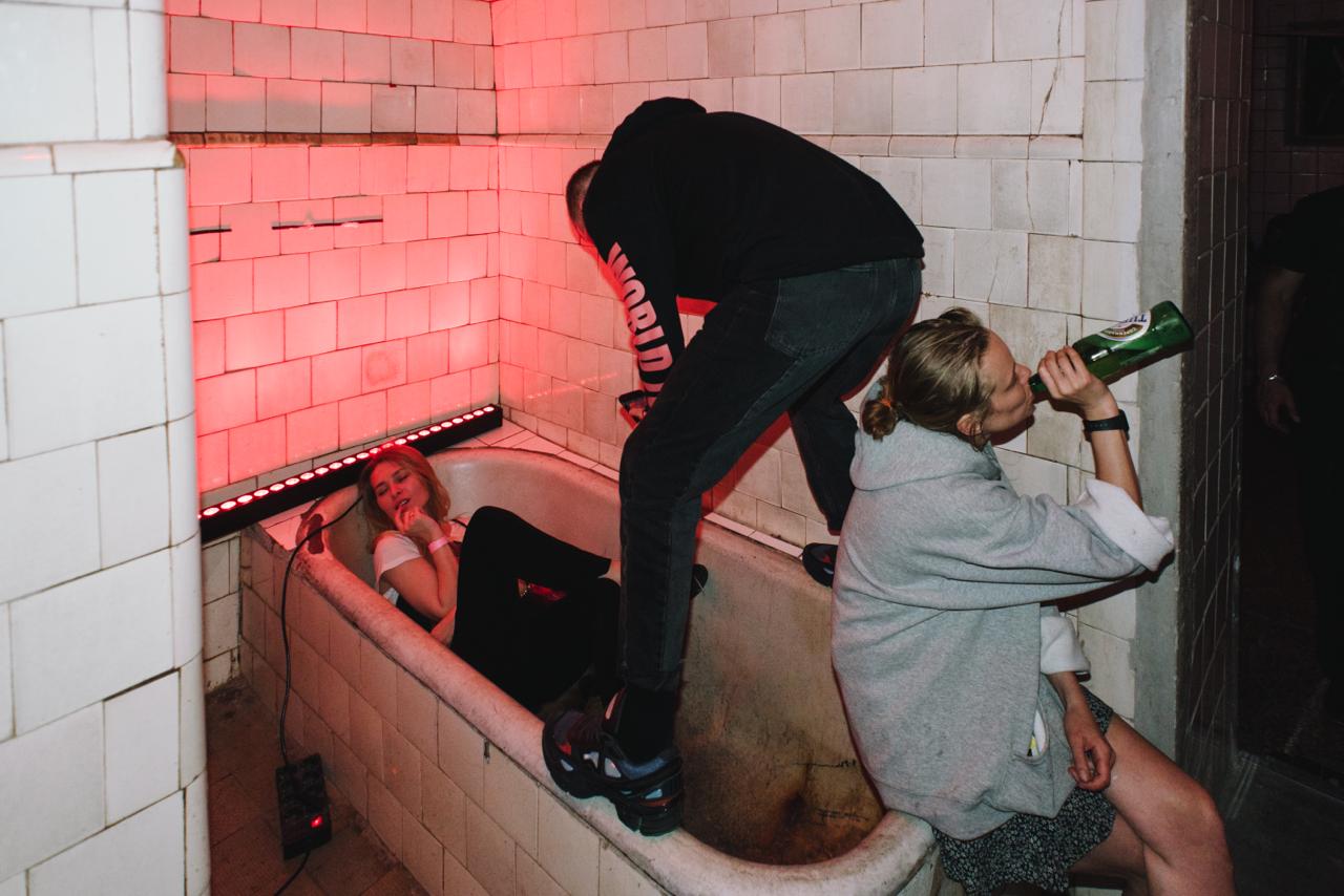 Young people with alcohol in an abandoned room, reflecting party culture and millennials’ attitudes toward drinking alcohol