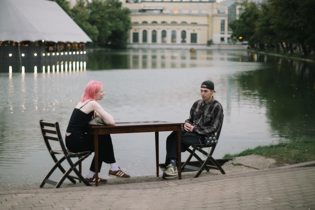 Man and woman talking by the water, symbolizing the influence of technology and AI on modern relationships