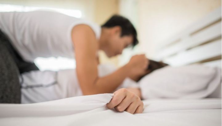 A man and a woman in bed, symbolizing the faking of an orgasm during intimacy with a partner