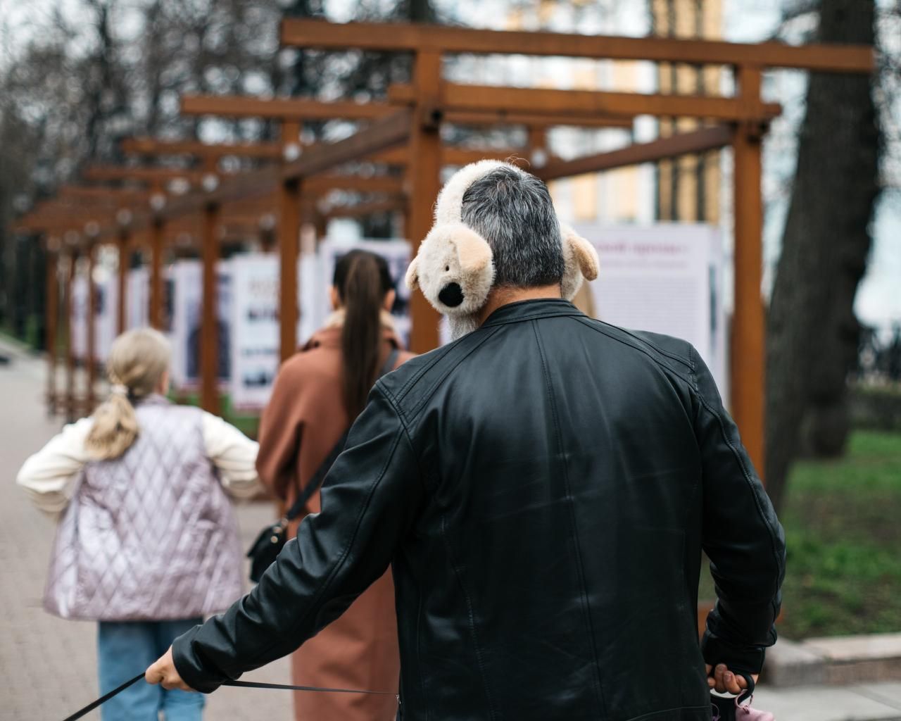 A man wearing plush headphones walks down the street amidst a crowd - a symbol of emotional distance, loneliness, and differing perceptions of intimacy and relationships